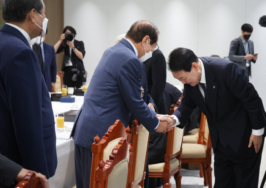 윤석열 대통령이 21일 서울 용산 대통령실 청사에서 열린 국민의힘 상임고문단 초청 오찬 간담회에서 신경식 전 의원과 인사하고 있다.<연합뉴스>
